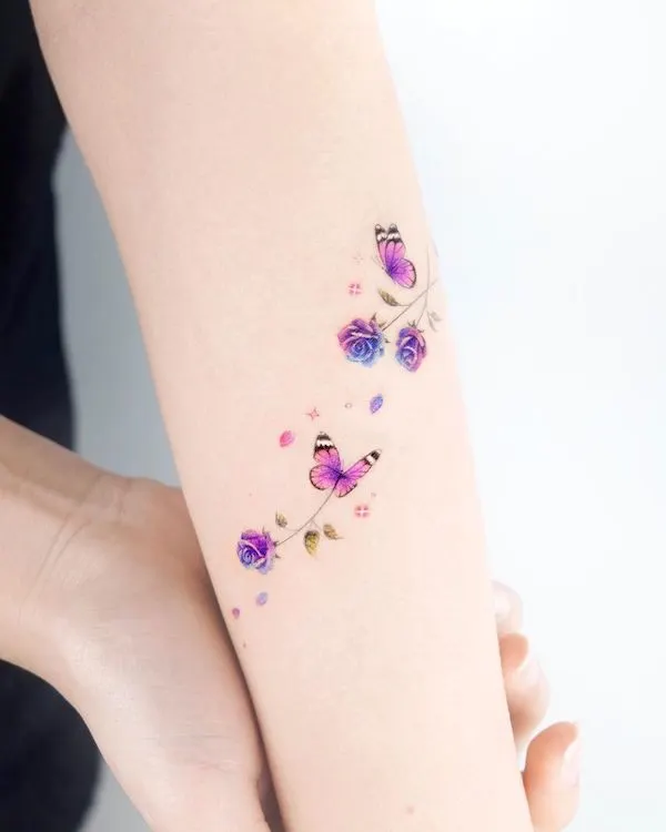 Tatuaje de brazo de mariposas y rosas por @coy.tattoo