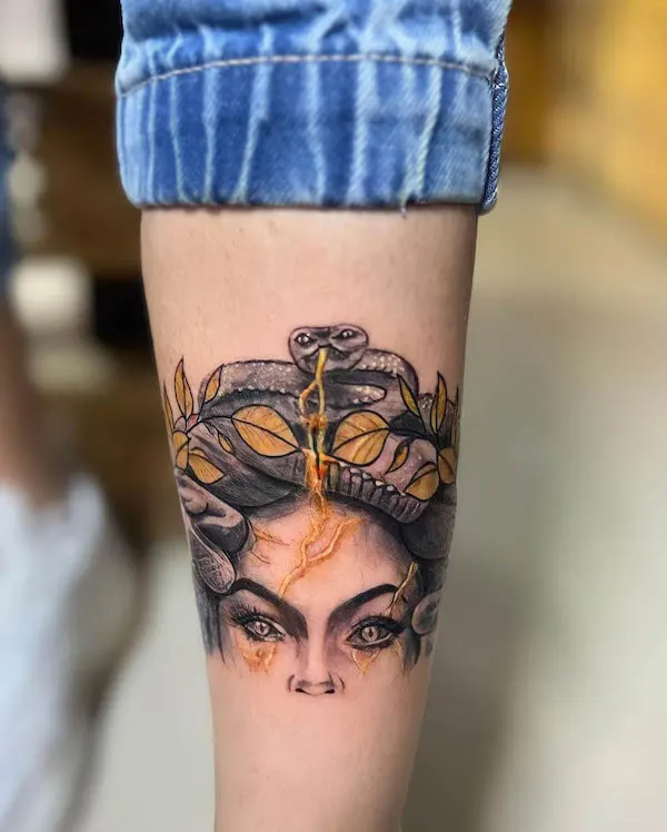 Tatuaje de becerro de Medusa dorada por @dannytatt00