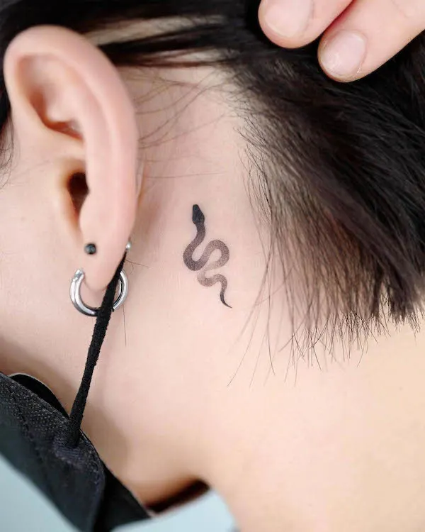 Pequeña serpiente detrás del tatuaje de la oreja por @choiyun_tattoo